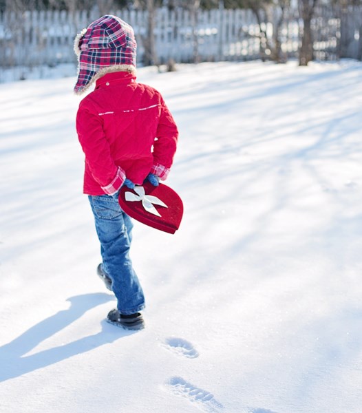child_in_the_snow_holding_a_heart_box
